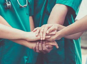 Doctors and nurses coordinate hands.