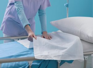 Expert young nurse making the bed at the hospital