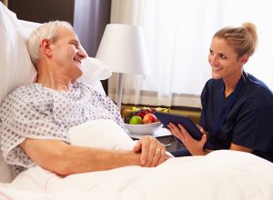 urse Talking To Senior Male Patient In Hospital Bed