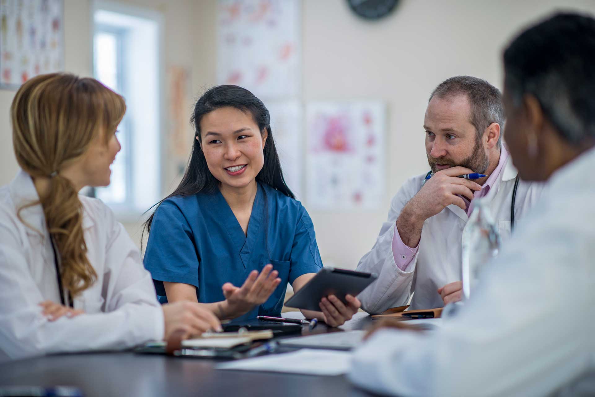 a group of doctors and nurses having a discussion using sentact digital platform