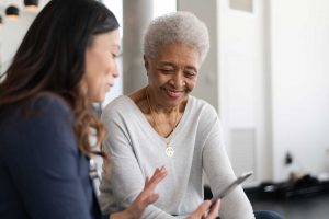 doctor talking to an elderly patient while holding a tablet using sentact technology